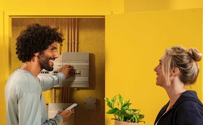 Dame en heer bij een meterkast in huis